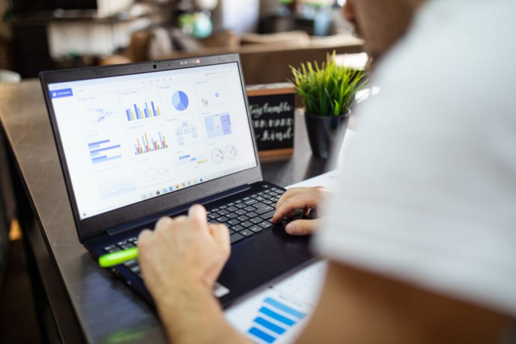 pexels photo 7947999 7947999 Focused business analysis with charts and graphs on a laptop in a modern office setting.